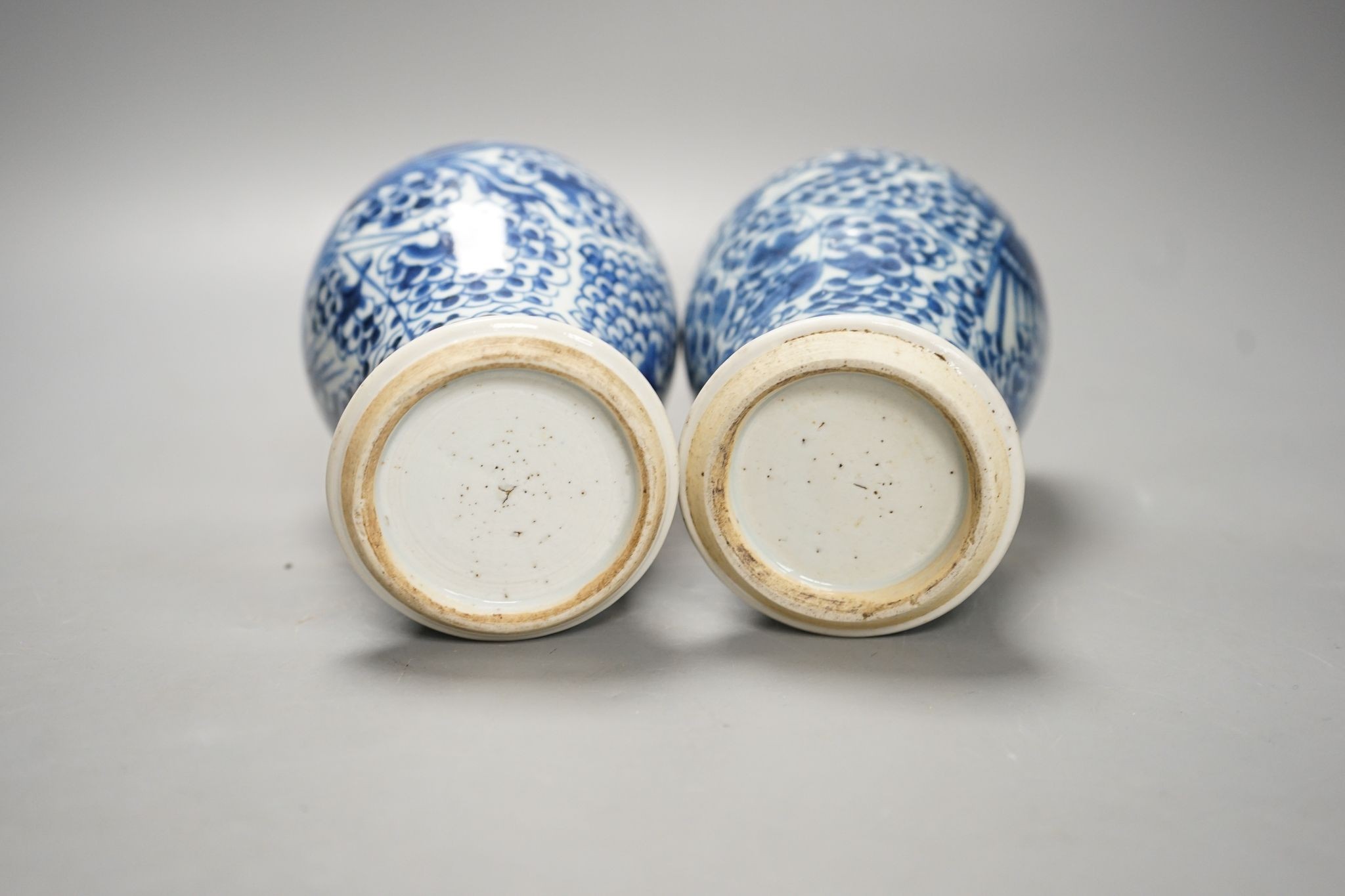 A pair of Chinese blue and white 'phoenix' vases, Kangxi, associated wood covers, 19cm including covers